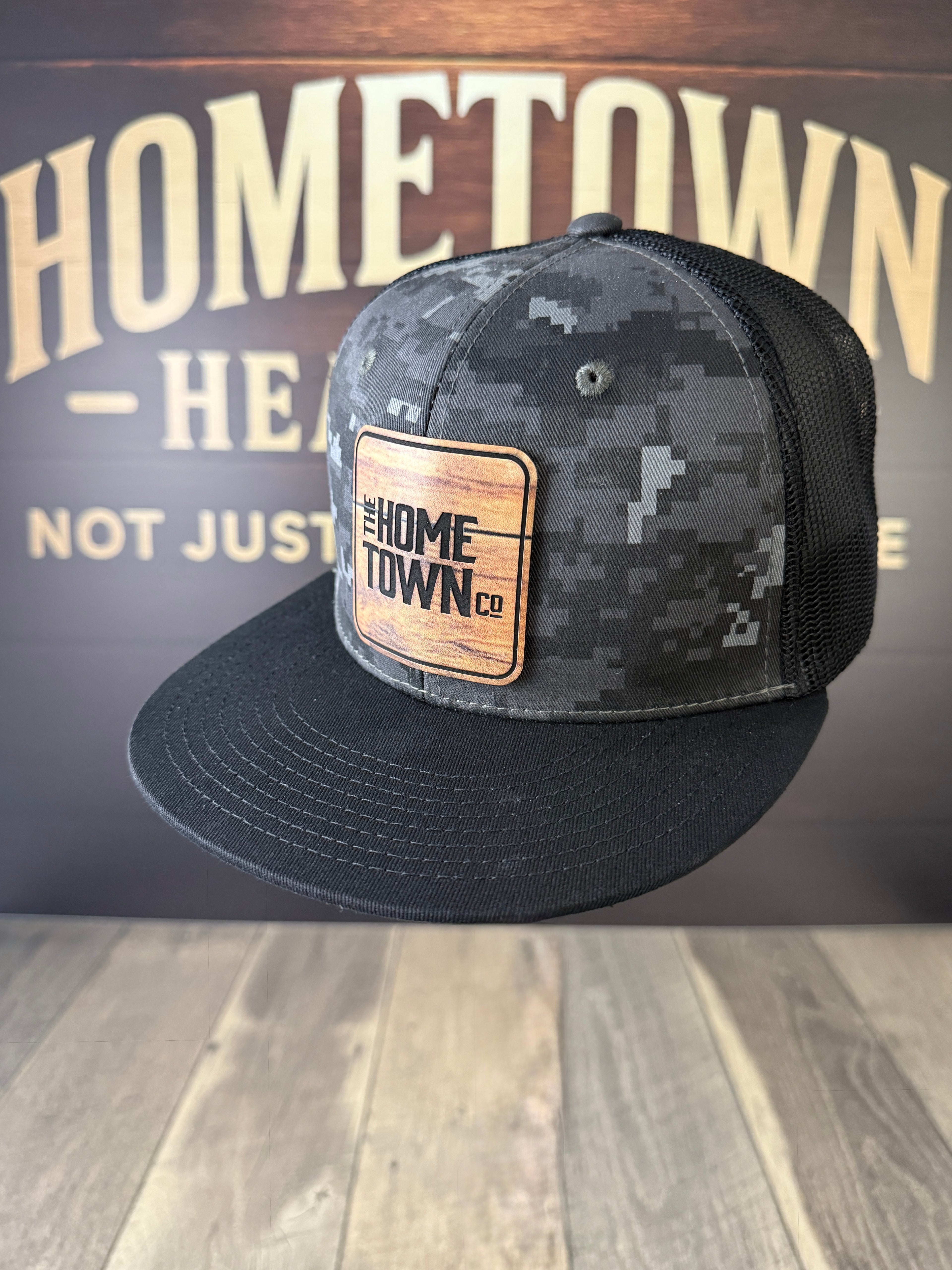 Black digi camo hat with UV printed dark wood grain leatherette patch.