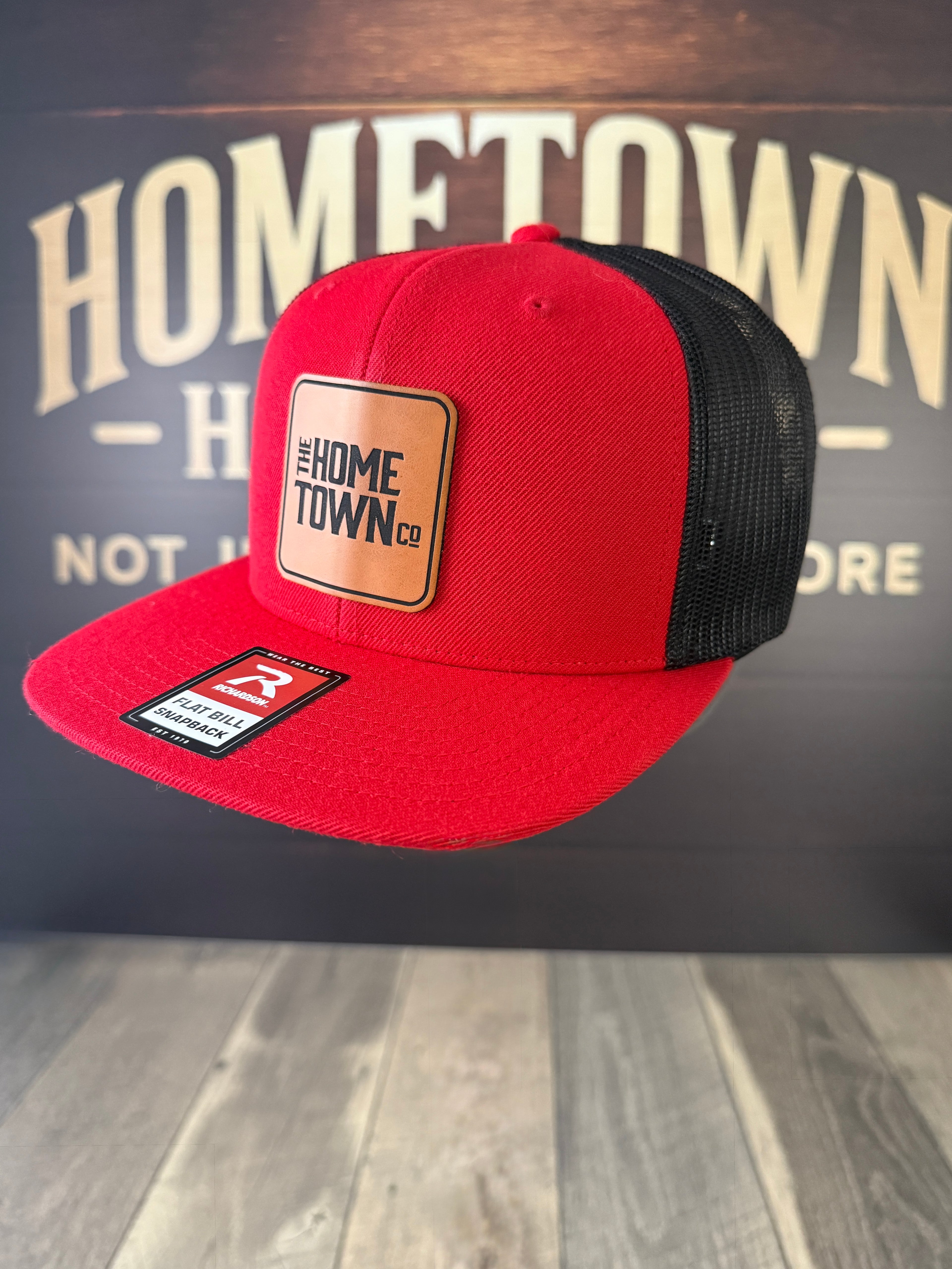 Red and black snapback hat with square leather patch, Signature Leatherette.